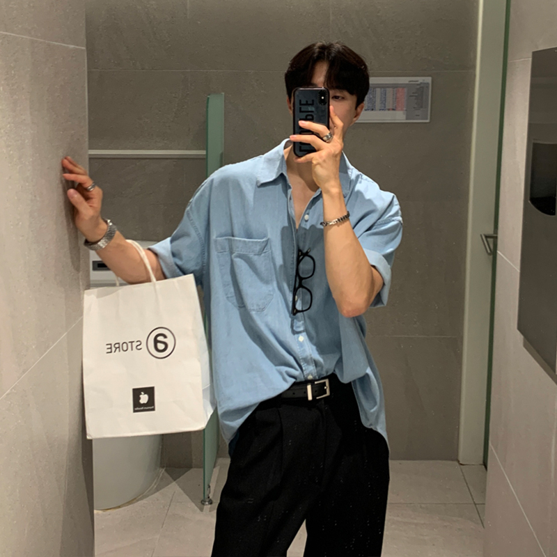 Side-parted hair + wayfarer sunglasses + sky-blue camp-collar shirt + matte-black belt + jet-black pleated trousers