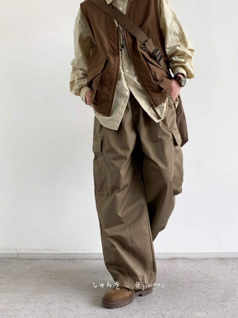 Rust canvas cross-body + Chocolate utility vest + Sand button-down + Olive cargo parachute pants + Weathered brown work boots