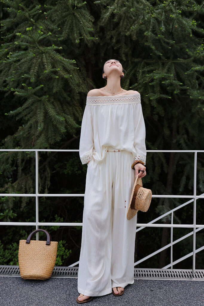 Straw sunhat + lace off-shoulder blouse + woven-belted ivory palazzo pants + brown flip-flops