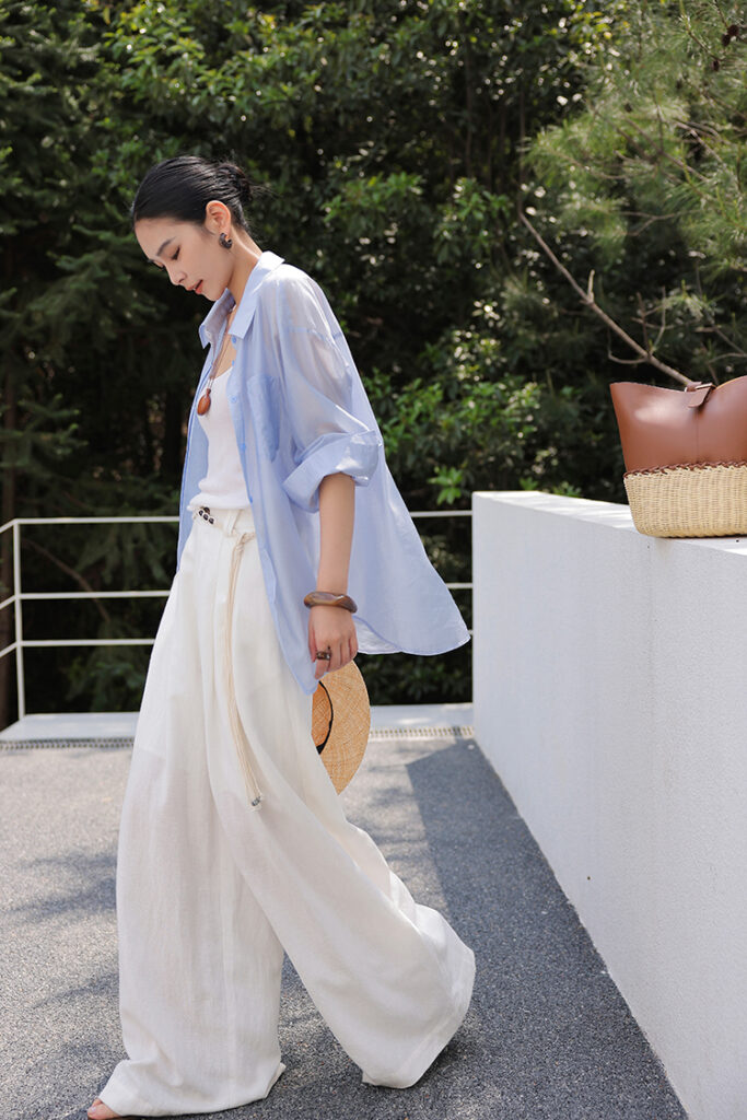 Bun up-do + sheer powder-blue overshirt + white rib tank + ivory wide-leg trousers + rope belt