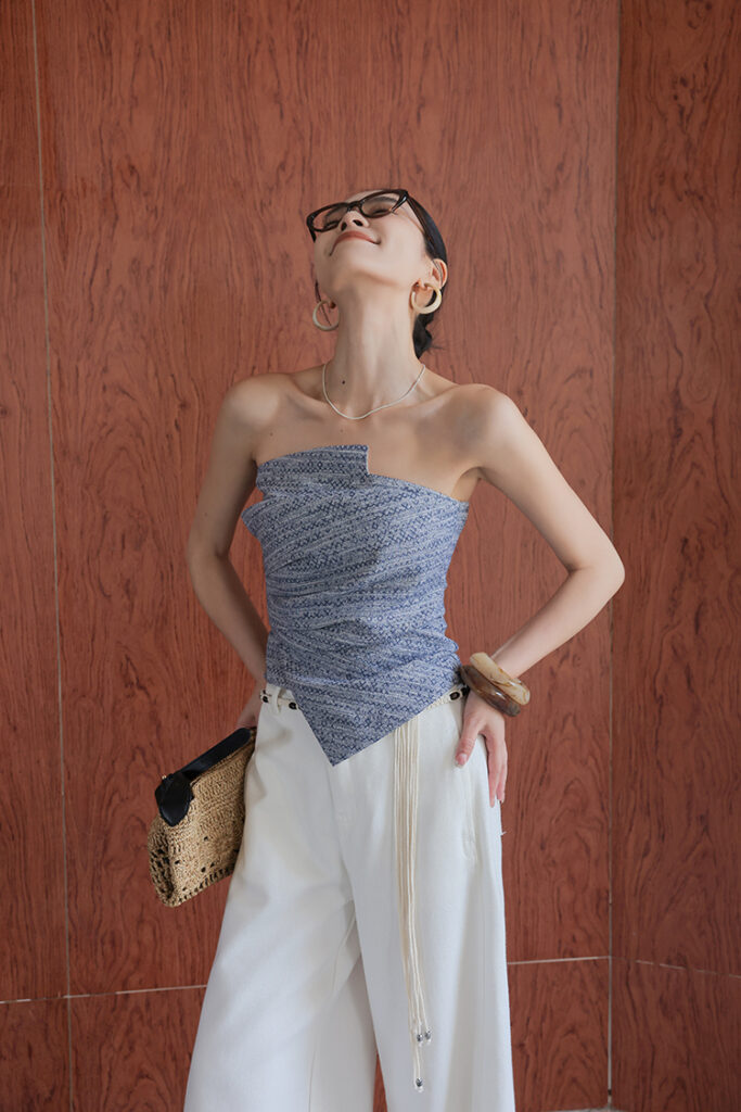 Tortoiseshell glasses + blue asymmetrical corset bandeau + white wide-leg trousers
