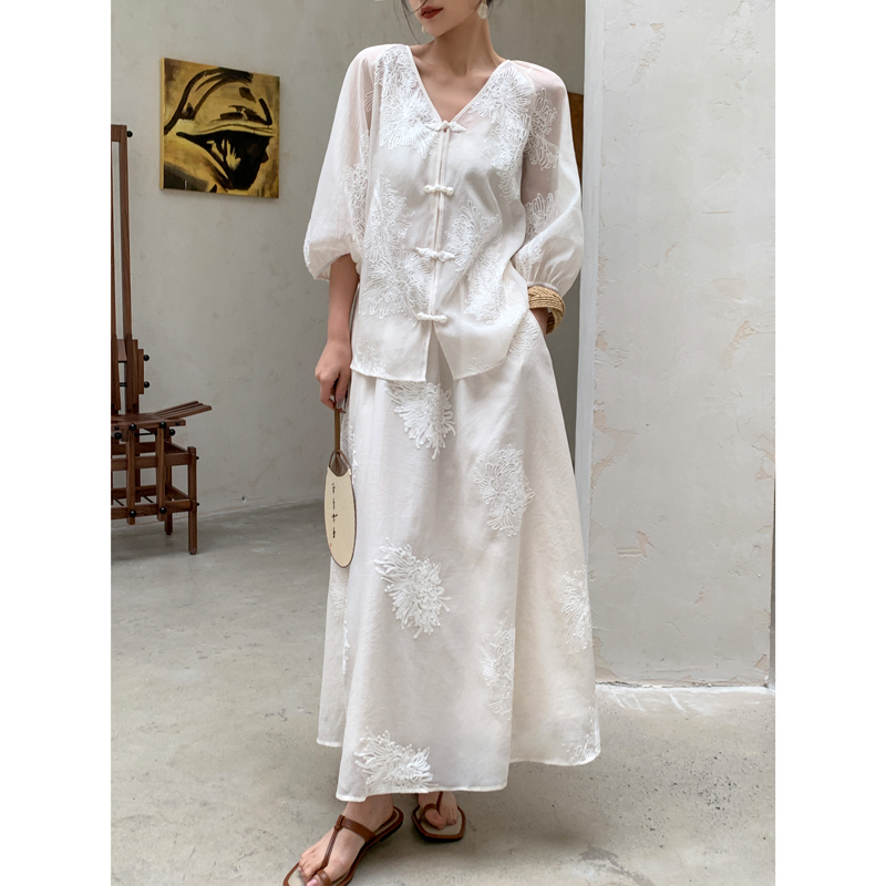Low bun + hand fan clutch + embroidered frog-button blouse + matching A-line midi skirt + brown thong sandals