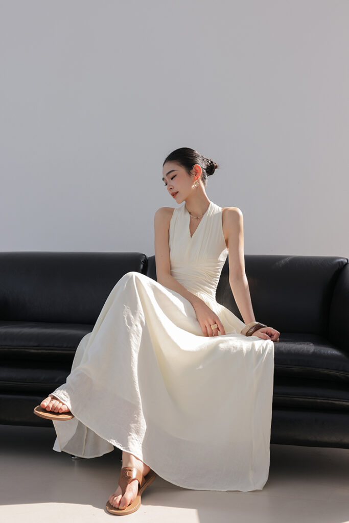 Low chignon + pearl stud earrings + ivory ruched halter gown + tan leather sandals