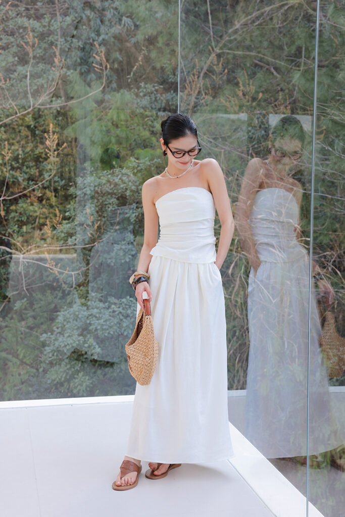 Slick pony + cat-eye glasses + strapless ruched top + pleated white maxi skirt + woven tote + tan sandals